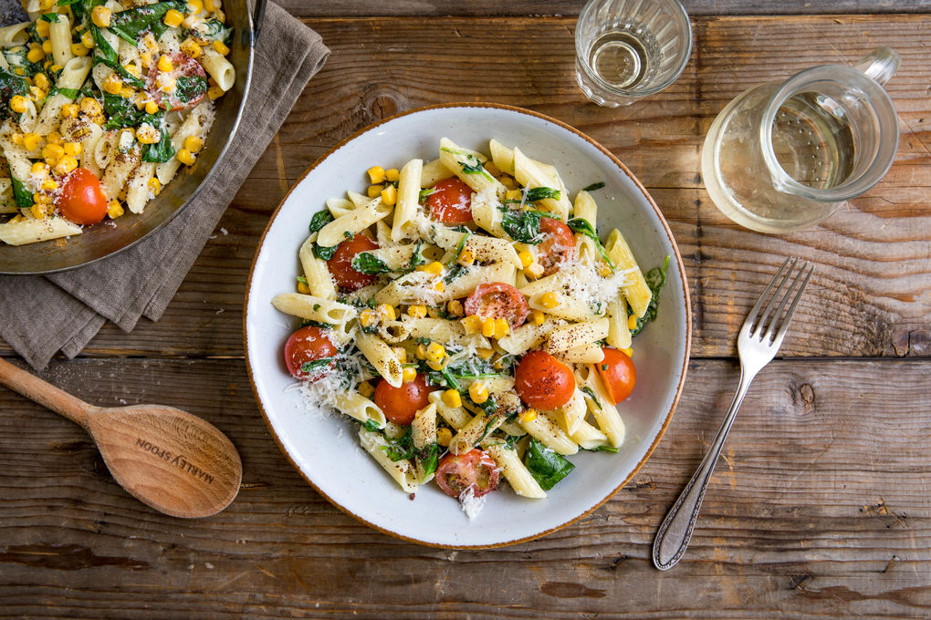 Penne mit Mais und Tomaten in cremiger Spinat-Käse-Sauce